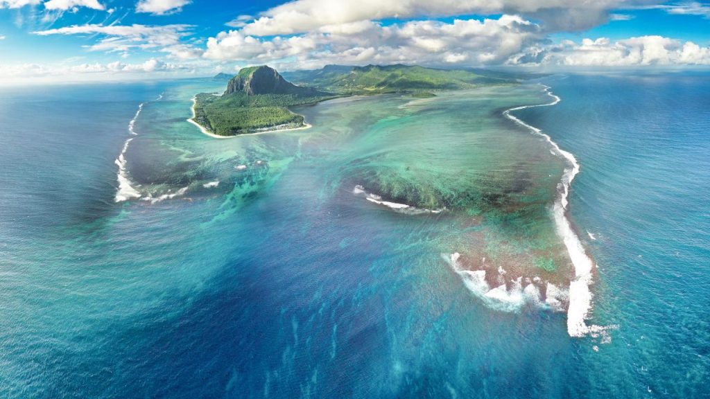 8 Secret Islands That Look Straight Out of a Movie (You Won’t Believe #3 Exists) Some places on Earth look so surreal that they seem crafted by visual-effects teams rather than nature. These islands hide landscapes that bend reality, volcanic craters with entire villages inside them, forests that look alien, and coastlines so dramatic they feel storyboarded for an epic film. What makes them even more astonishing is that many remain barely visited, left untouched by mass tourism. Their isolation preserves a kind of atmospheric magic: a silence you can feel, a stillness that pulls you into another dimension. 1. SocotraDream — Socotra Socotra is often called the most alien-looking island on Earth, but experiencing it in person is something words barely capture. The iconic dragon blood trees, with their umbrella-shaped canopies and crimson resin, stand like monuments from another world. Their presence transforms the entire island into a natural science-fiction scene, as if a film crew might emerge from behind the rock formations at any moment. The beaches are empty and blindingly white, the mountains jagged and windswept, and the air filled with scents from endemic plants found nowhere else. 2. SabaRise — Saba Saba is a volcanic island so steep and compact that arriving feels like dropping into a vertical world suspended between sea and sky. Its single winding road, famously hand-carved by residents, climbs dramatically upward through dense green slopes until it reaches a cloud-covered village of white cottages and red rooftops. The air cools as you ascend, and suddenly you are surrounded by mist that swirls around homes perched along the mountainside like a hidden settlement in a fantasy tale. Unlike typical Caribbean destinations, Saba has no sprawling beaches or resort strips. 3. AogaCrater — Aogashima Aogashima is one of the most unbelievable inhabited places on the planet, a remote volcanic island that contains a smaller crater nested inside a larger one. The village, tucked quietly within this inner caldera, makes the entire island appear like a hidden civilization living inside Earth’s own architecture. What astonishes visitors first is that this surreal landscape technically belongs to Tokyo, even though it sits far out in the Philippine Sea and feels like a sealed world detached from modern life. Steep cliffs ring the settlement, creating an amphitheater of green walls that rise dramatically on all sides, amplifying every sound carried by the wind. 4. HoweSanctum — Lord Howe Island Lord Howe Island feels as if it has been kept in a protective bubble where time moves slower and nature remains pristine. Strict visitor limits preserve its untouched atmosphere, allowing the island to exist as a quiet sanctuary of turquoise lagoons, towering peaks, and bird-filled forests. The dramatic shapes of Mount Gower and Mount Lidgbird give the island an elemental presence, rising sharply from the sea like the spines of an ancient creature. The lagoon glows in shifting shades of blue, and its clarity reveals coral formations that look hand-arranged for an underwater film set. 5. BellaFloat — Isola Bella Isola Bella is one of the most theatrical islands in Europe, a place where architecture and landscape blend into a single ornate masterpiece. The grand Baroque palace dominates the island, rising above the lake with terraces that cascade downward like steps of an elegant stage. Each terrace is adorned with statues, blooming gardens, and sweeping views that create an atmosphere of regal fantasy. Approaching by boat feels like drifting toward a floating kingdom crafted for a historical drama, complete with dramatic symmetry and impossibly detailed stonework. 6. TristanEdge — Tristan da Cunha Tristan da Cunha is the most remote inhabited island on Earth, a tiny volcanic speck in the South Atlantic surrounded by vast stretches of ocean. Its isolation alone gives it cinematic gravitas, but the island’s sharp volcanic slopes and rugged coastline amplify that sense of otherworldliness. The small settlement, Edinburgh of the Seven Seas, exists against a backdrop of towering green cliffs and ever-changing weather that moves in dramatic waves across the landscape. Life here revolves around community and resilience, with supply ships arriving only a few times a year, heightening the feeling of existing at civilization’s edge. 7. KauaiVeil — Kauai Kauai, often called the Garden Isle, possesses a cinematic richness that has drawn filmmakers for decades, yet experiencing it in person exceeds any on-screen depiction. The Na Pali Coast’s jagged emerald cliffs rise abruptly from the ocean, forming ridges and valleys sculpted by centuries of wind and rain. These formations create a dramatic interplay of shadow and light throughout the day, making the landscape appear to breathe. Inland, the island reveals canyons, waterfalls, and highland marshes that feel mythic, almost as though they hide stories older than human presence. 8. ElNidoGlow — El Nido El Nido is a dreamlike labyrinth of limestone cliffs rising vertically from electric-blue waters, forming a natural fantasy world that seems almost painted. Its lagoons shimmer in shades that shift from jade to crystal, and navigating them feels like moving through secret chambers carved by time. The cliffs tower so dramatically that they create an enclosed feeling, as if you are floating through the set of an otherworldly adventure film. Hidden beaches lie tucked behind narrow openings, accessible only through small passages that add an element of mystery and discovery.