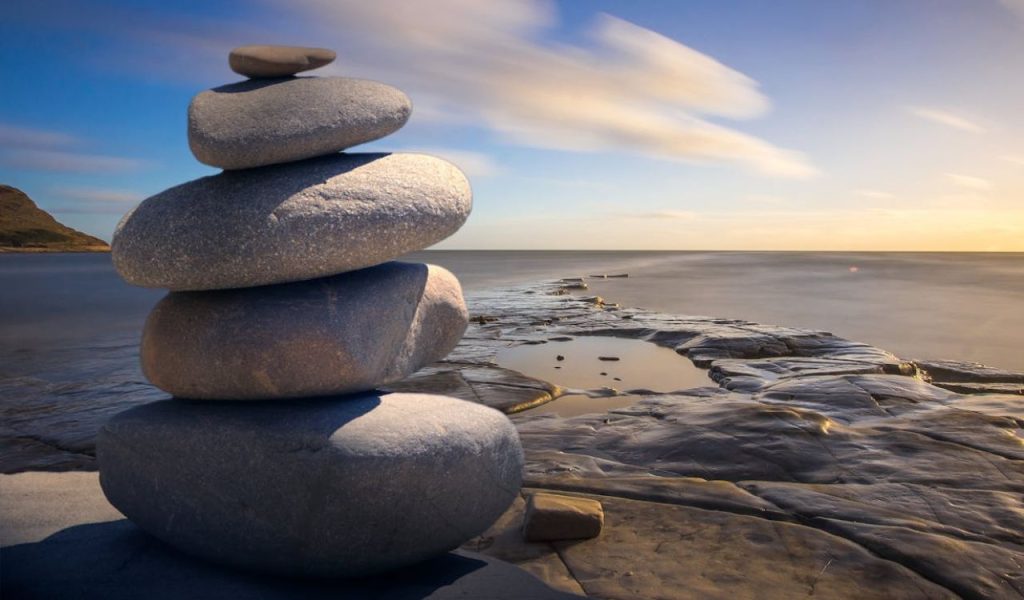 Stacked stones by the sea at sunset.