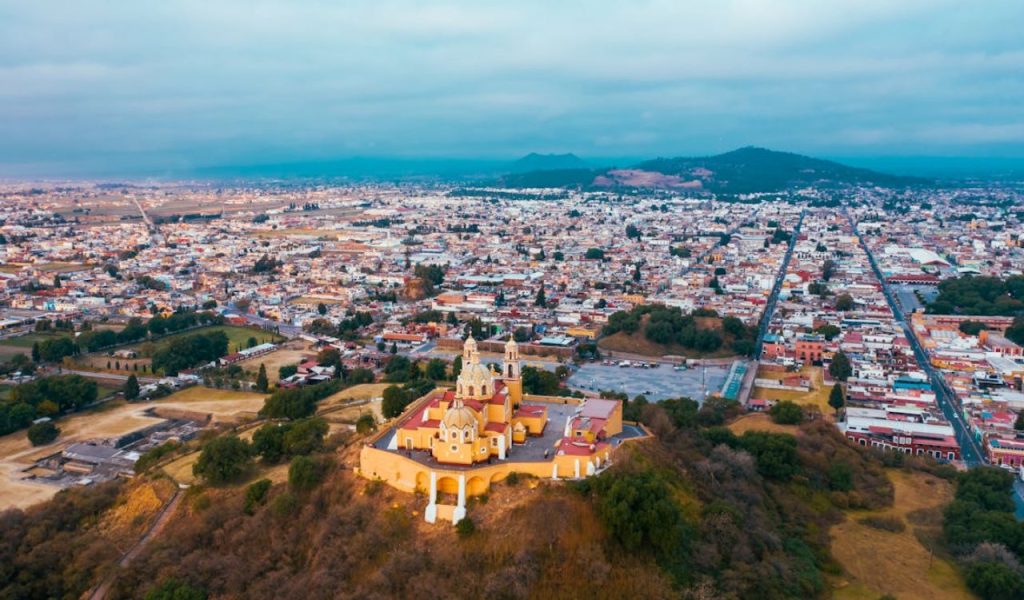 Aerial view of a hilltop church overlooking a sprawling city.