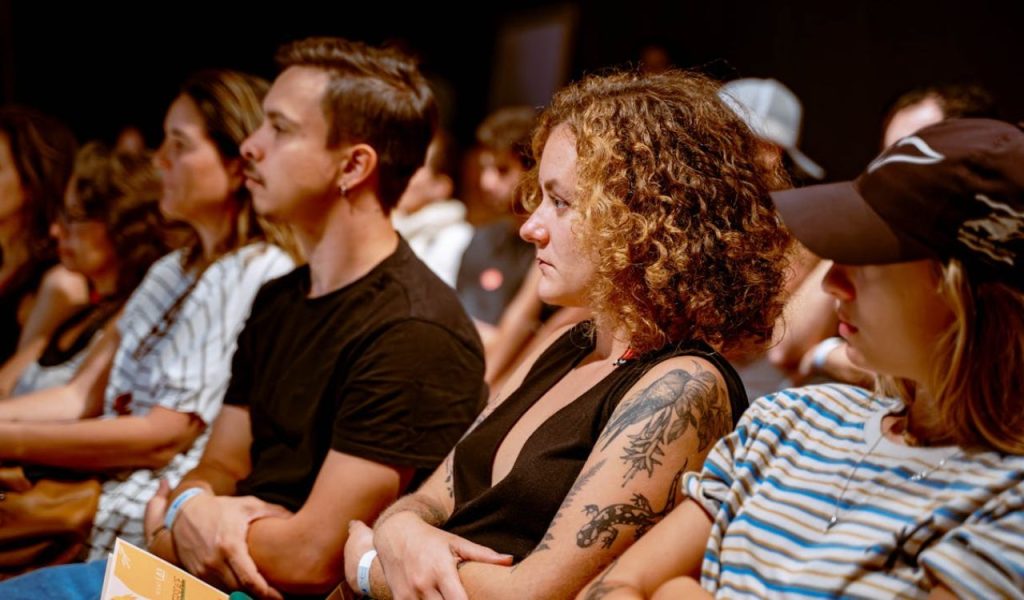 Audience listening attentively in a seated event.