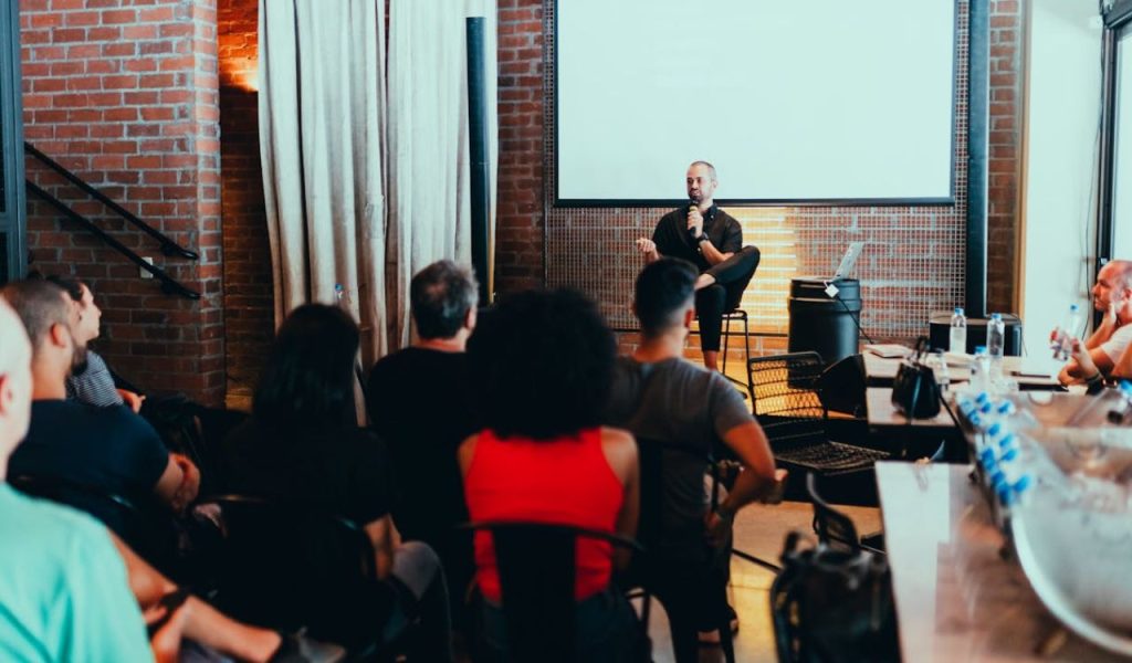 Speaker presenting to an audience in a room.