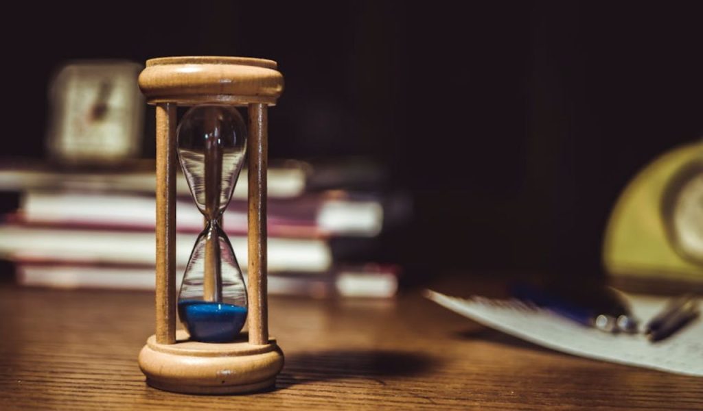 Close-up of an hourglass on a desk.