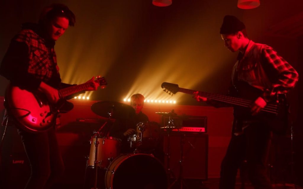 Grunge-style electric guitar on a stage with moody lighting.