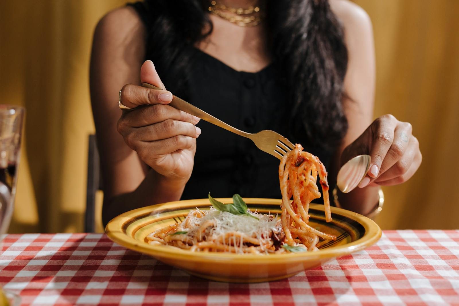 A woman enjoying traditional Italian pasta at a charming dining setting.