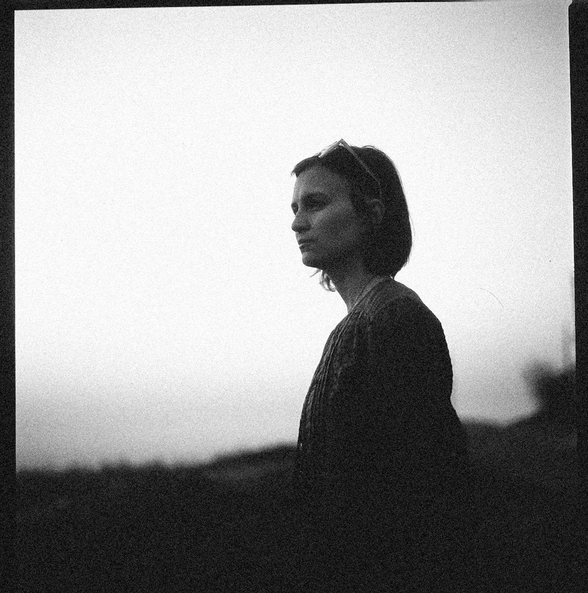 A thoughtful woman gazes into the distance in this dramatic black and white portrait.