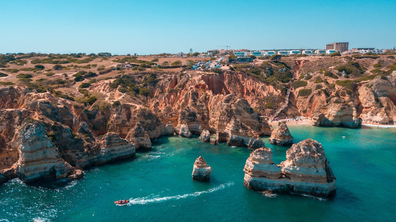 Stunning aerial shot of the rocky coastline in Lagos, Portugal's Algarve region, with clear blue sea.