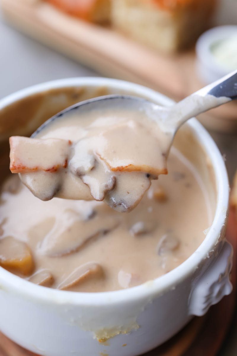 Delicious homemade creamy mushroom soup served in a white bowl with spoon