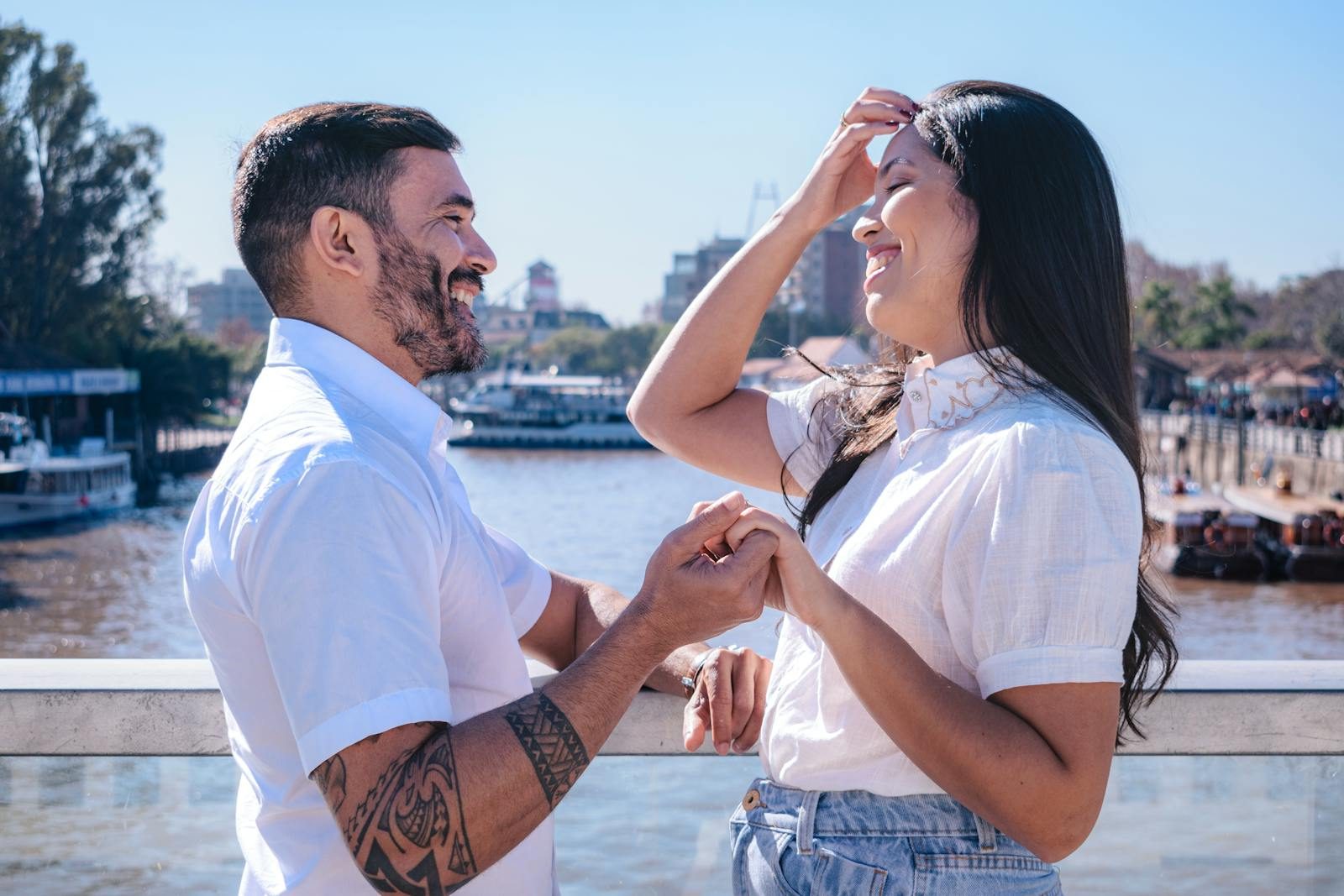 Joyful couple sharing a happy moment on a riverside bridge in Tigre, Buenos Aires Province, Argentina.