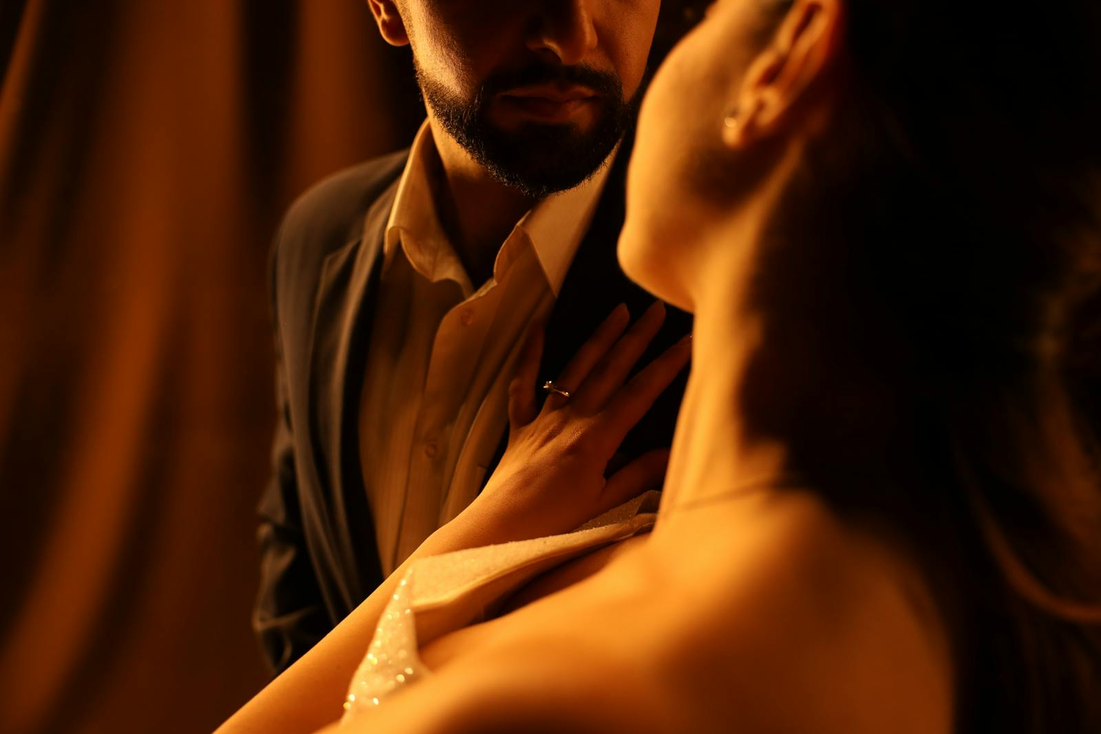 A couple in a warm, intimate embrace, captured in soft lighting, evoking romance.