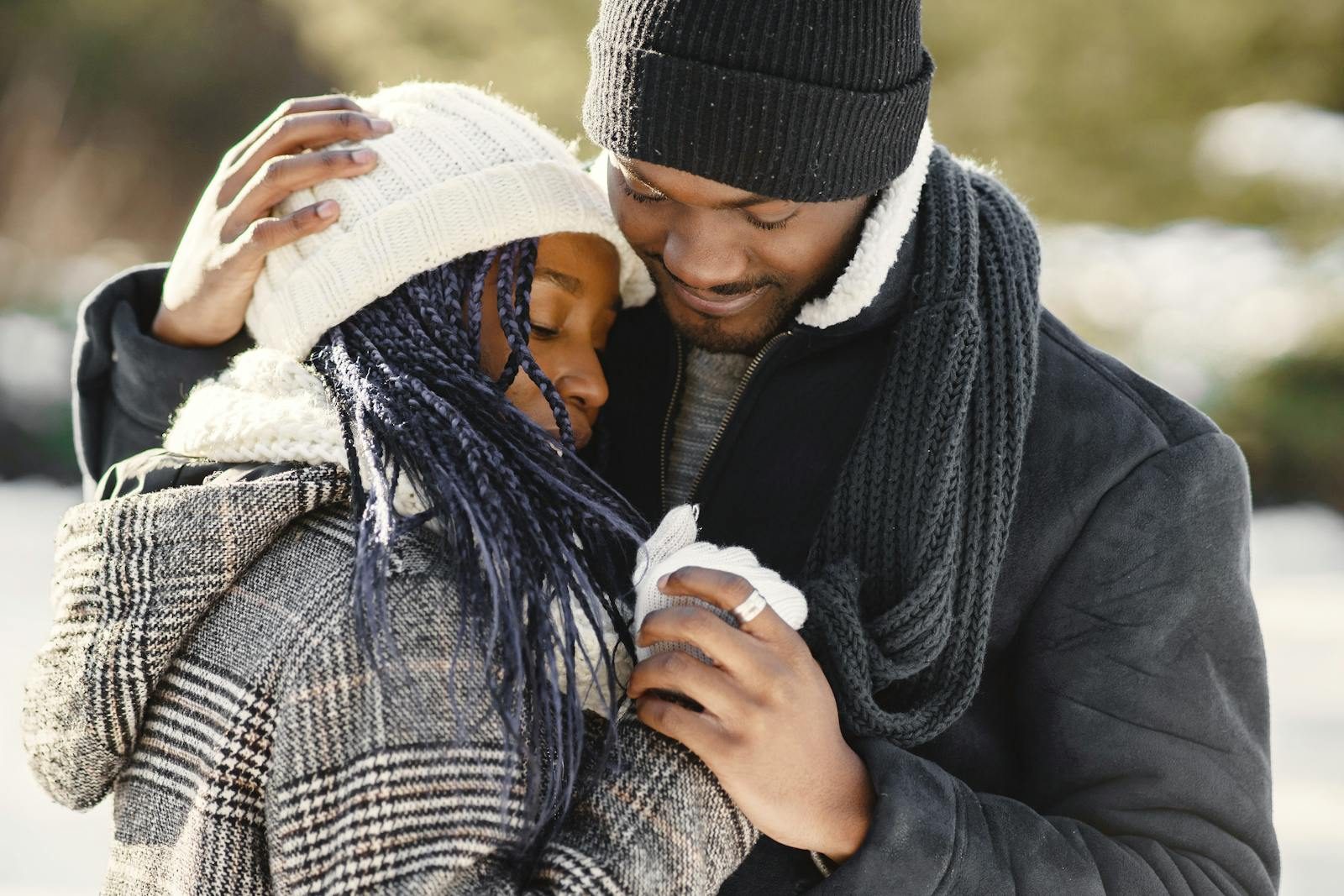 Cozy winter embrace of a young African American couple outdoors, exuding warmth and love.