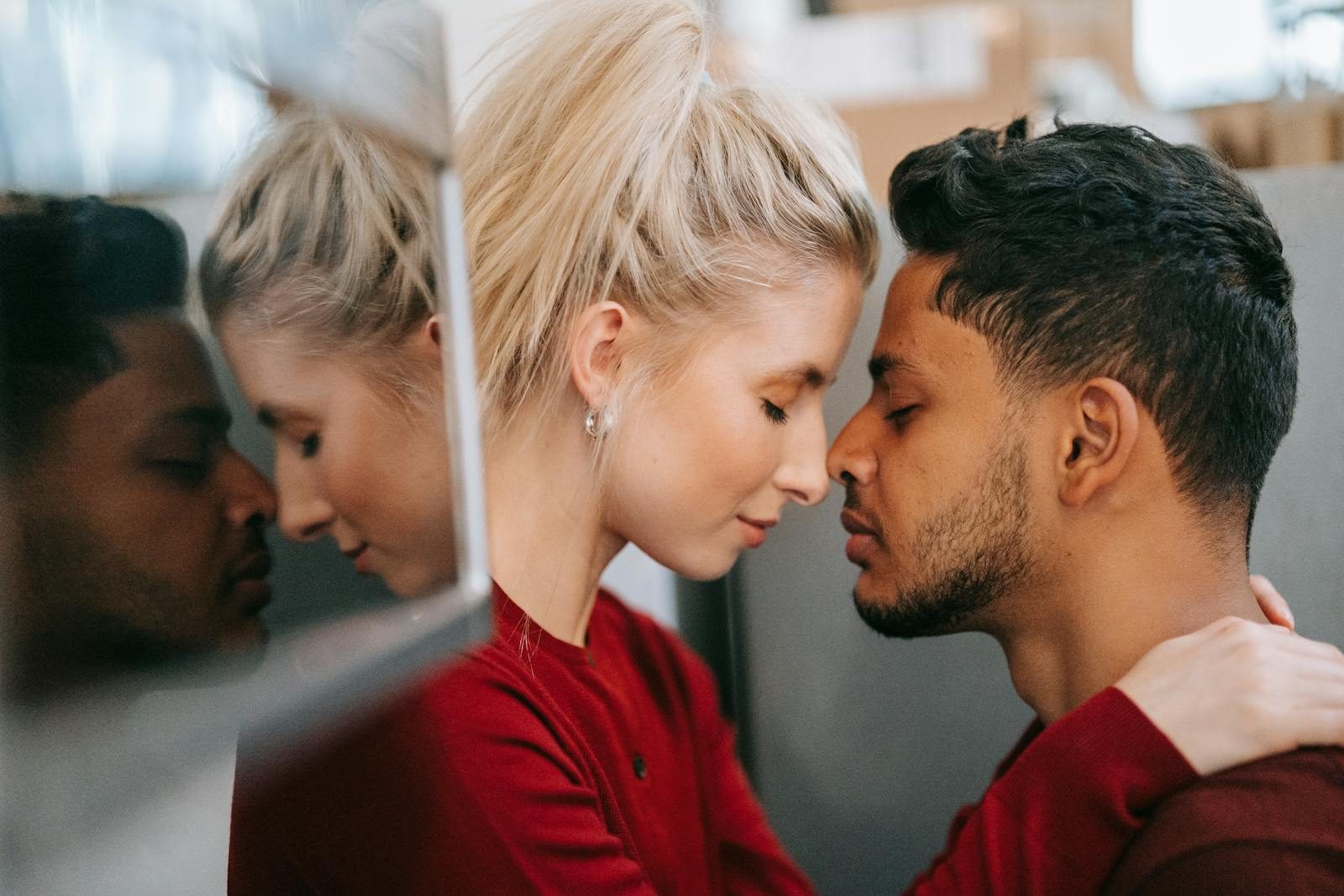 A couple sharing an intimate and tender moment face to face with closed eyes.
