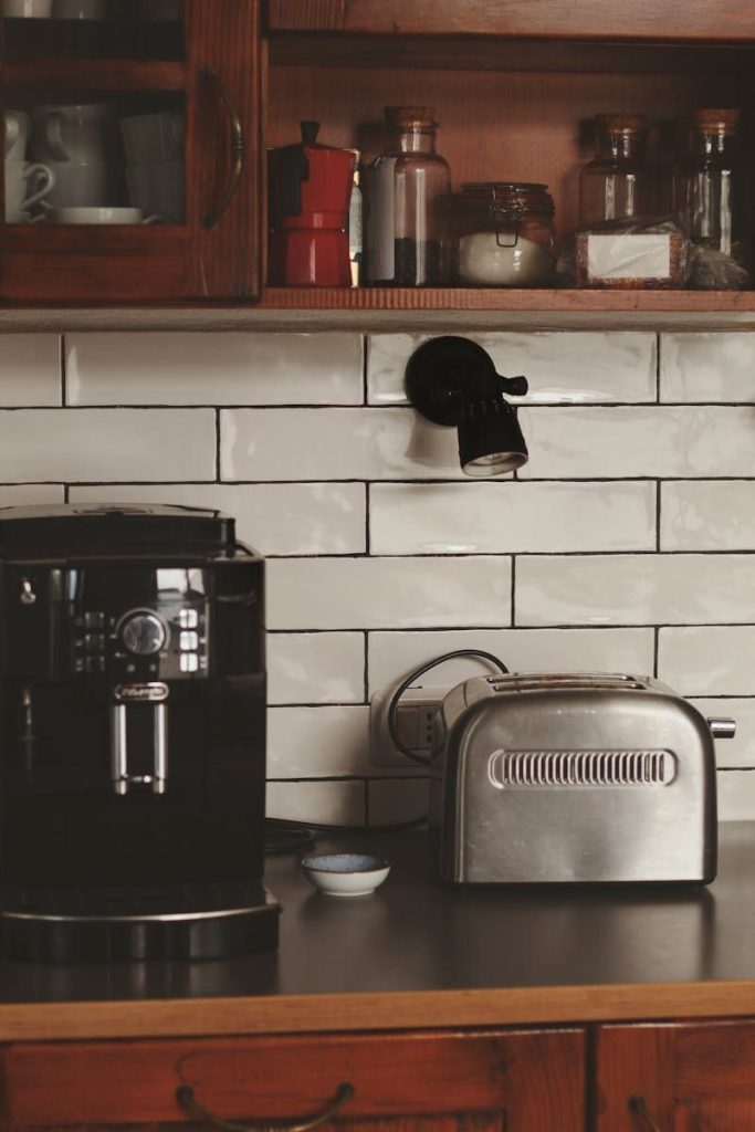 A sleek kitchen counter featuring a coffee machine and toaster, with spices stored above.