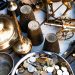 A collection of vintage brass items and coins arranged in a still life composition, showcasing historical artifacts.