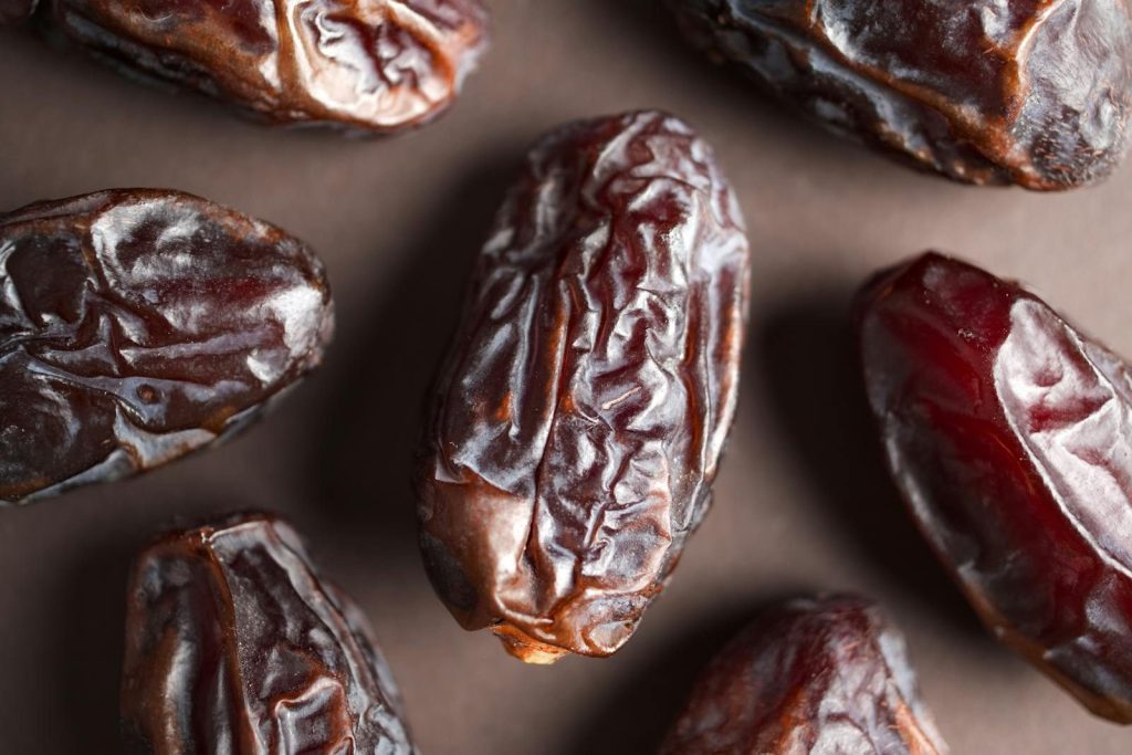 High-resolution close-up of wrinkled Medjool dates showcasing texture and rich color.