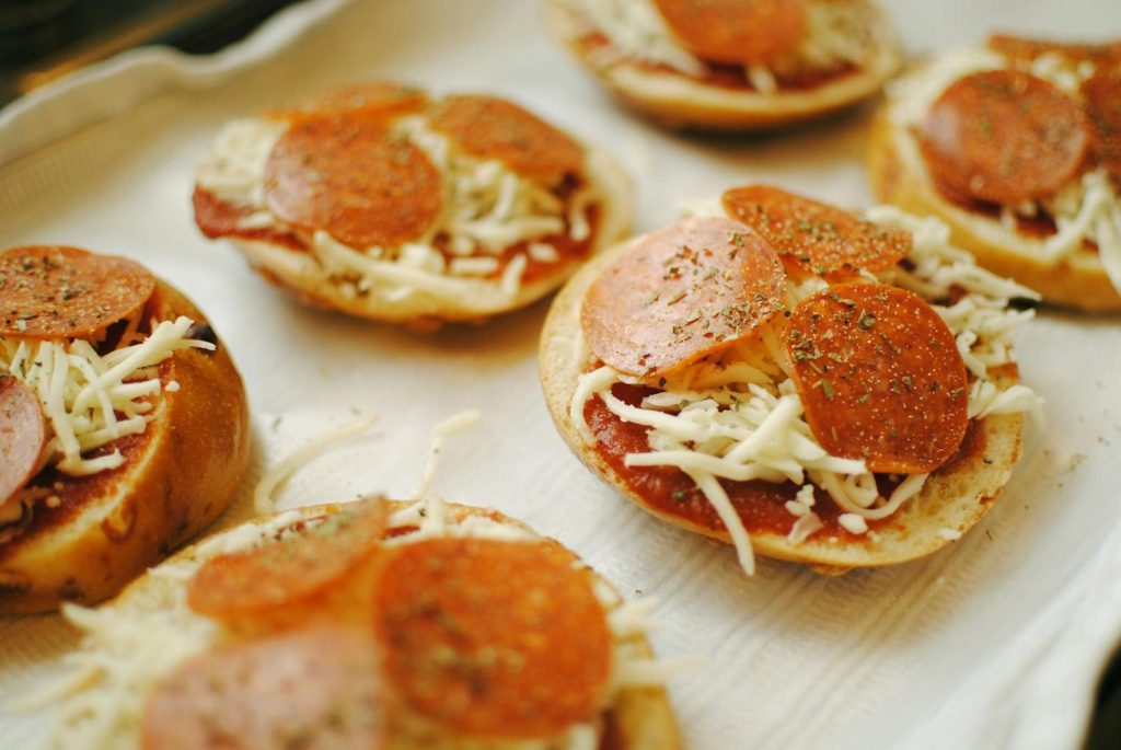 Close-up of fresh homemade pepperoni pizza bagels with cheese and herbs.