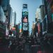 Vibrant Times Square in New York City filled with people and bright billboards during the day.