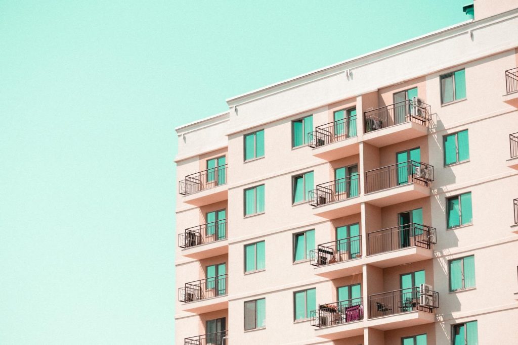 Modern apartment building facade with balconies under a clear blue sky.