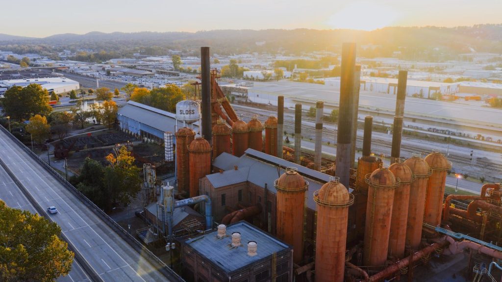 Aerial view of historic Sloss Furnaces in Birmingham, Alabama during sunset, showcasing industrial architecture.