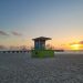 Colorful lifeguard tower at Pompano Beach during a serene sunrise over the ocean.