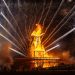 The iconic Burning Man effigy ablaze with surrounding fireworks at night.