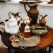 A collection of antique vases and pitchers artfully arranged on a vintage table indoors.