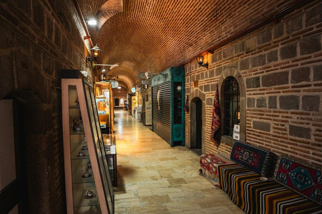 Explore a historic bazaar's interior corridor adorned with traditional decor and cultural artifacts.