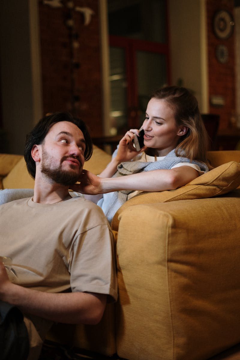A loving couple relaxing on a couch, enjoying a cozy evening at home. Perfect for lifestyle themes.