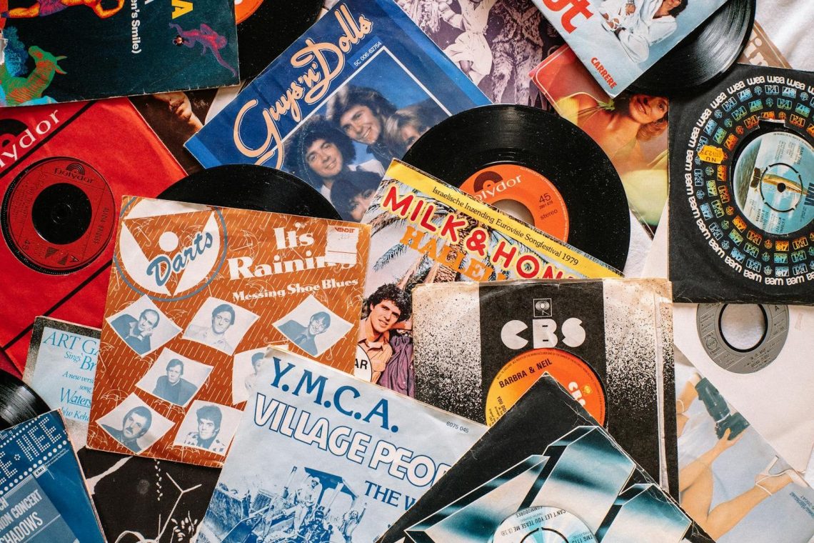 Top view composition of old fashioned vinyl discs in colorful packs heaped on table