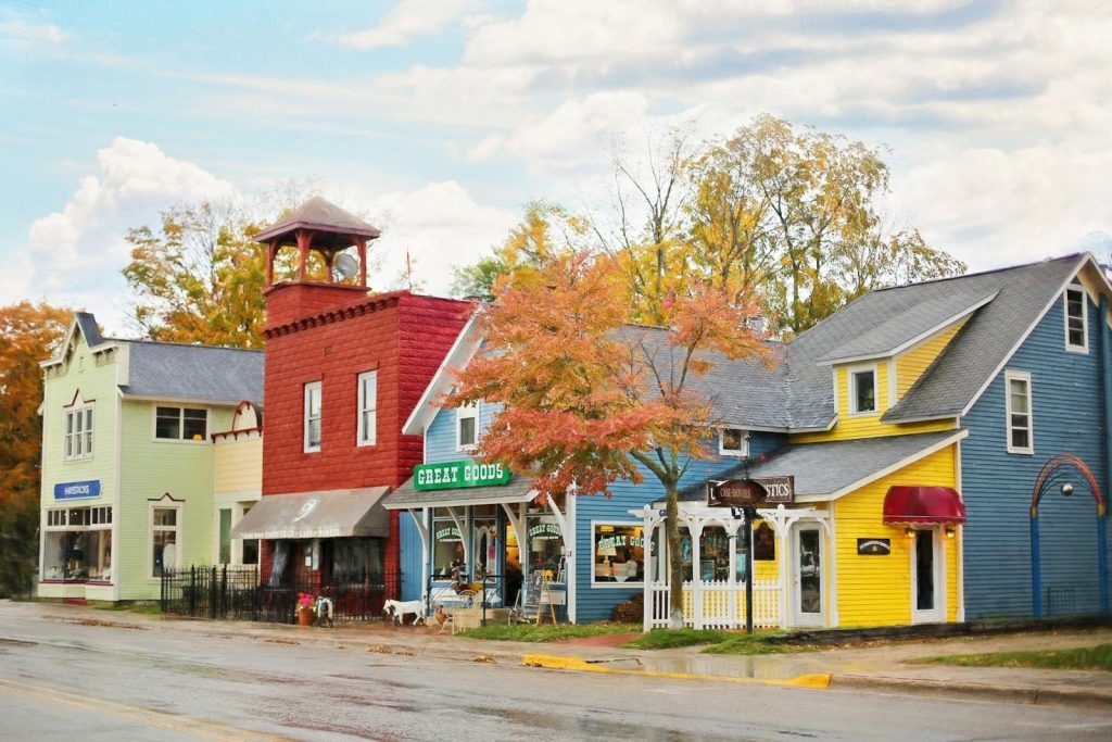 A vibrant street scene with colorful buildings and quaint shops under autumn skies.
