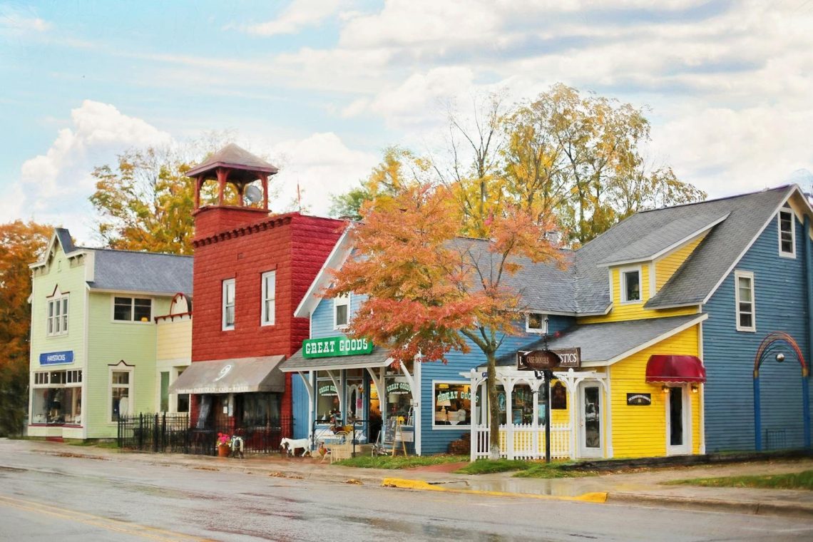 A vibrant street scene with colorful buildings and quaint shops under autumn skies.