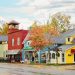 A vibrant street scene with colorful buildings and quaint shops under autumn skies.