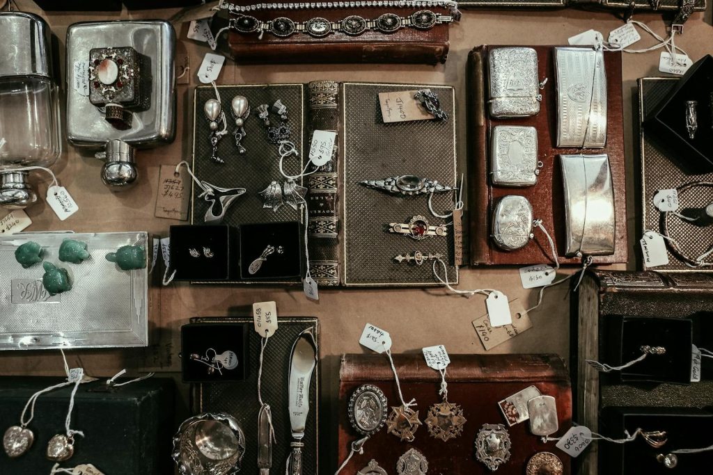 A curated selection of vintage and antique items on a display, including jewelry, books, and decorative pieces.