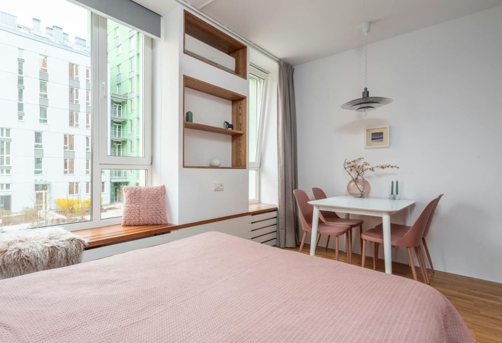Contemporary design of room with soft bed near wide window and comfortable furniture