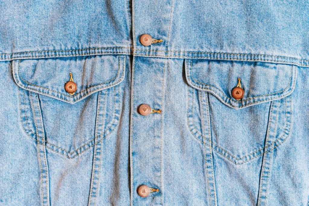 High-resolution close-up of a denim jacket showcasing button and pocket details, perfect for fashion themes.