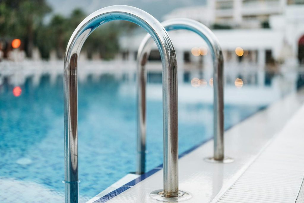 Close-up of a pool ladder at a serene resort, evoking summer vacation vibes.