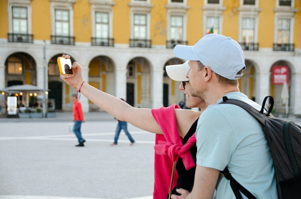 A couple takes a selfie in a beautiful square.